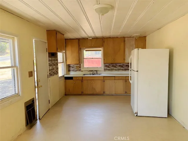 a kitchen with a refrigerator a sink and cabinets