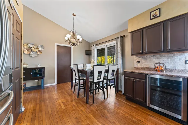 a dining room with furniture a chandelier and wooden floor