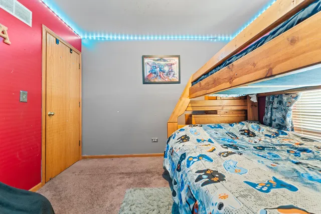 a bedroom with a bed and a painting on the wall