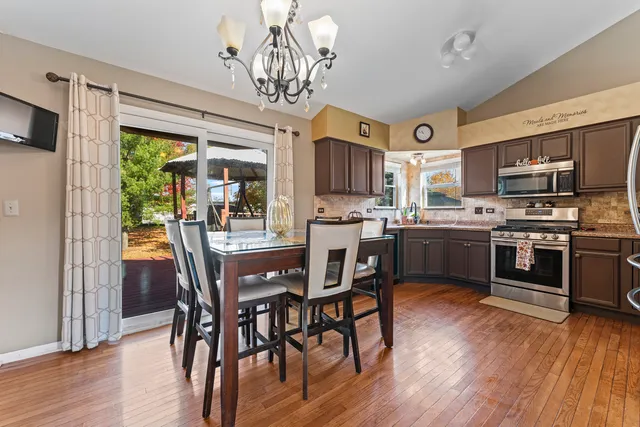 a view of a dining room with furniture a chandelier and wooden floor