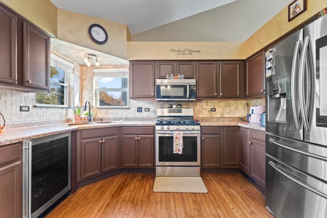 a kitchen with kitchen island granite countertop a sink cabinets and stainless steel appliances