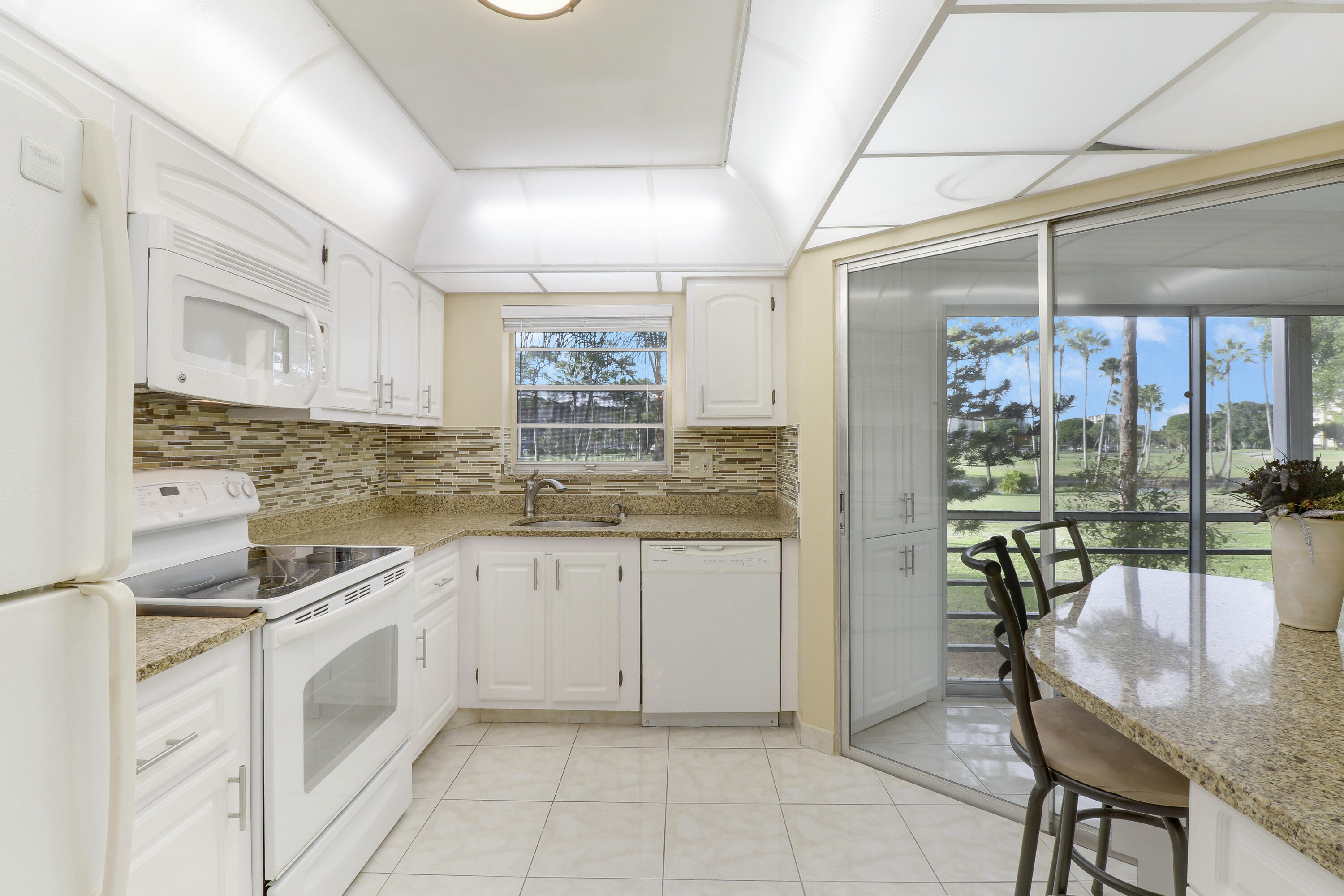 a kitchen with granite countertop white cabinets a dining table and chairs