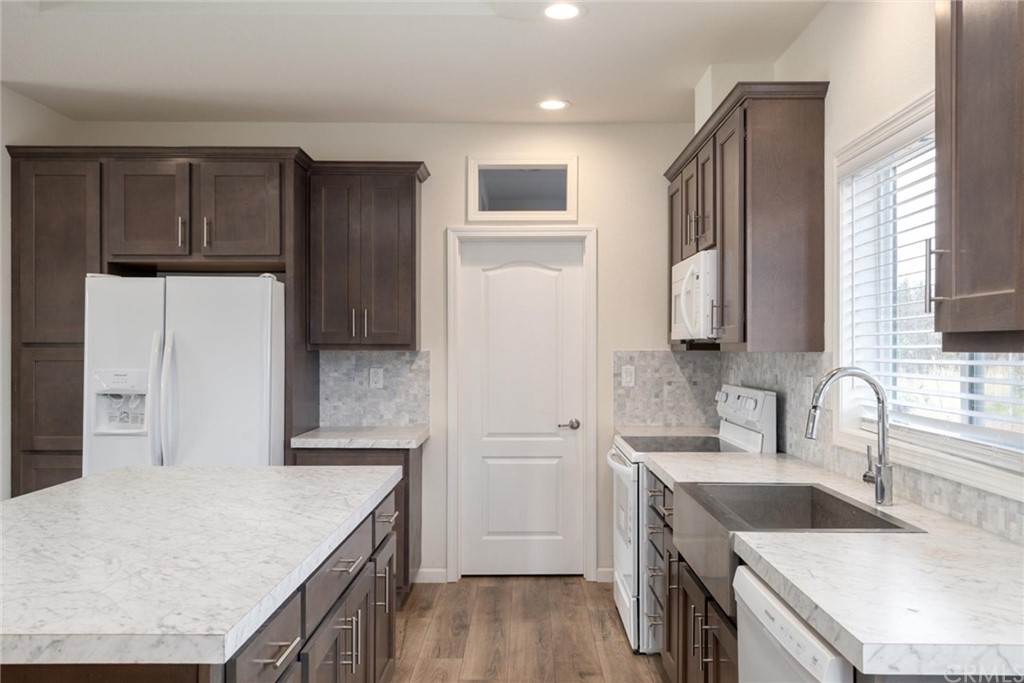 12980 Mohawk Way Concow, CA 95965 - Photo 11 of 26 a kitchen with stainless steel appliances granite countertop a refrigerator a stove and a sink with wooden floors