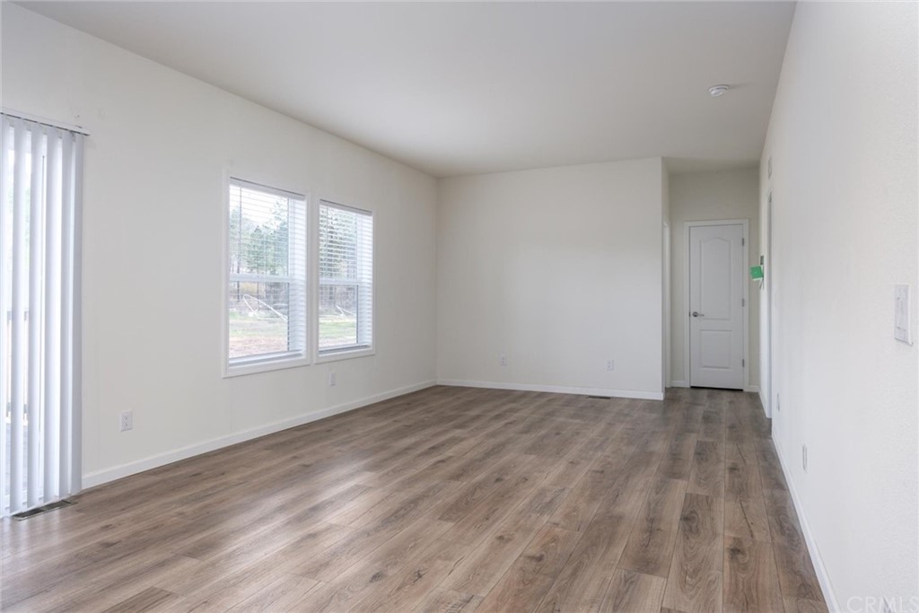 12980 Mohawk Way Concow, CA 95965 - Photo 7 of 26 an empty room with wooden floor and windows