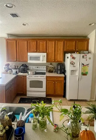 a kitchen with refrigerator a sink a stove and a window