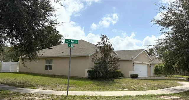 a view of a house with a yard and tree
