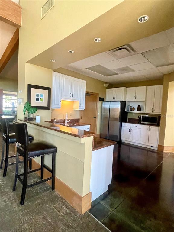 3921 Southwest 58th Avenue Ocala, FL 34474 - Photo 28 of 31 a kitchen with stainless steel appliances kitchen island granite countertop a table chairs and a refrigerator