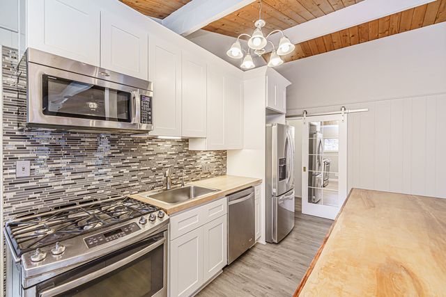 a kitchen with stainless steel appliances a stove a sink and a microwave