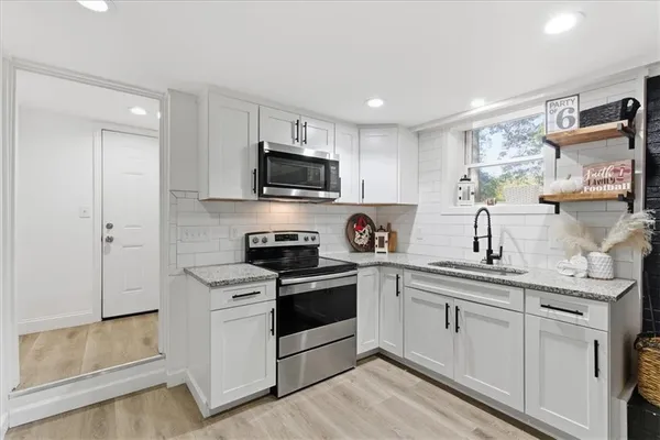 a kitchen with white cabinets stainless steel appliances and sink