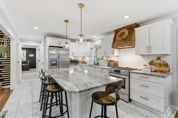 a kitchen with granite countertop kitchen island and stainless steel appliances