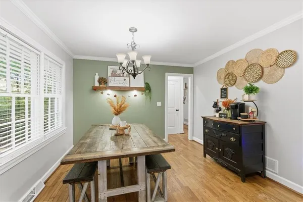 a view of a dining room with furniture a chandelier and wooden floor