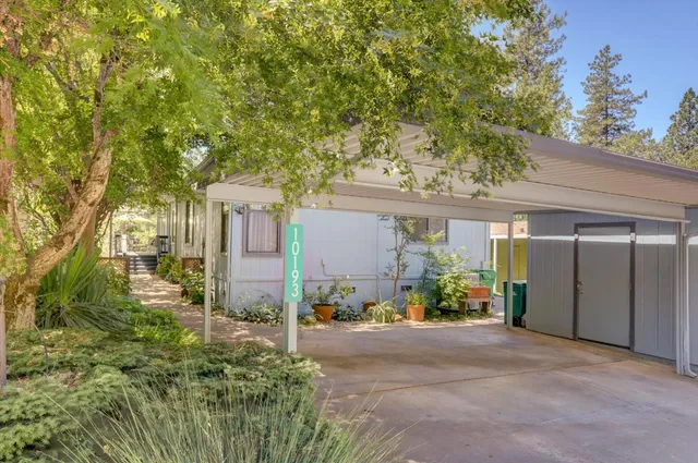 a view of a house with a yard and potted plants