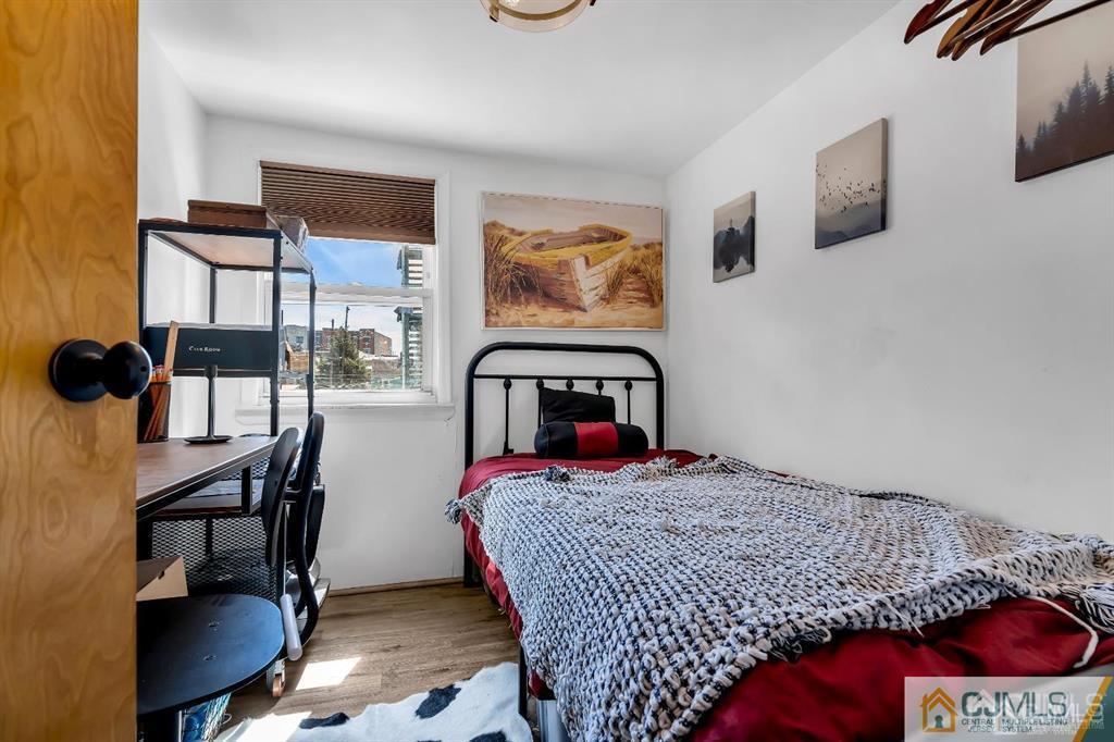 7 Downing Street Newark, NJ 07105 - Photo 12 of 18 a bedroom with a bed and dresser next to a window
