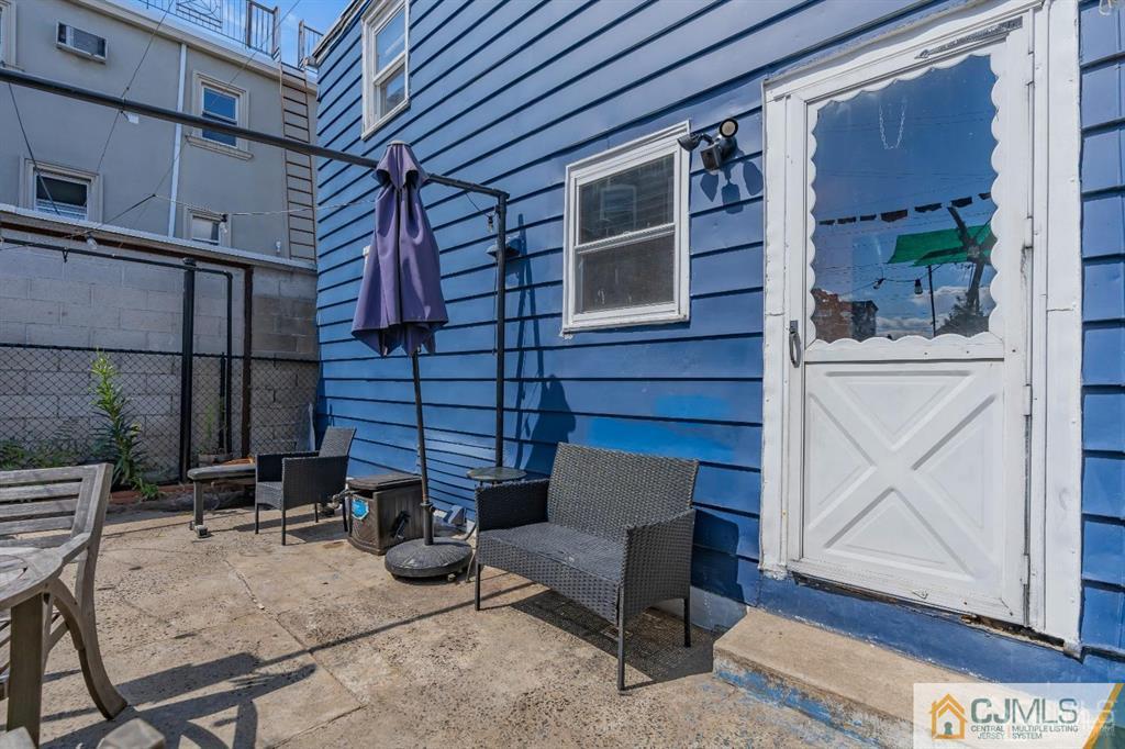 7 Downing Street Newark, NJ 07105 - Photo 18 of 18 a view of backyard with outdoor seating and wooden fence