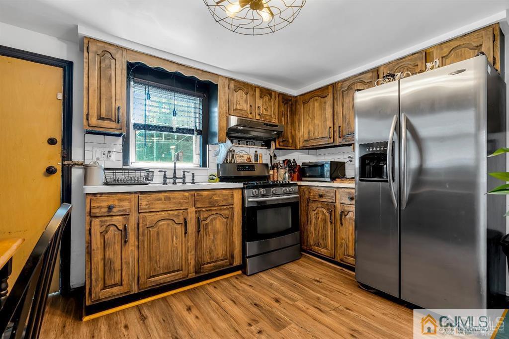 7 Downing Street Newark, NJ 07105 - Photo 7 of 18 a kitchen with stainless steel appliances granite countertop a refrigerator a sink dishwasher a stove with wooden cabinets and floor