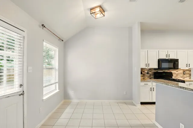 a kitchen with granite countertop a stove a sink and a microwave
