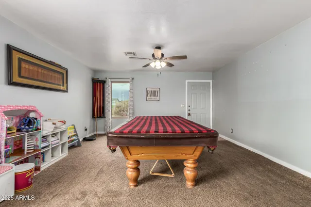a room with furniture pool table and a ceiling fan