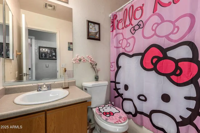 a bedroom with a bed and a flat tv screen on dresser
