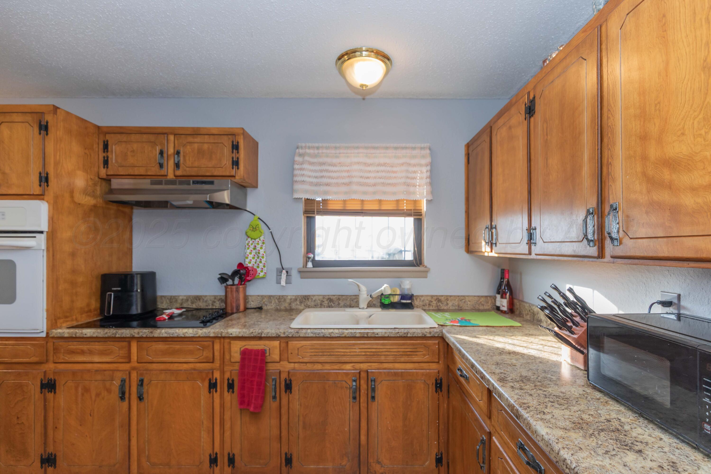 1208 Pecan Street Amarillo, TX 79107 - Photo 11 of 34 a kitchen with stainless steel appliances granite countertop a sink a stove cabinets counter space and a window