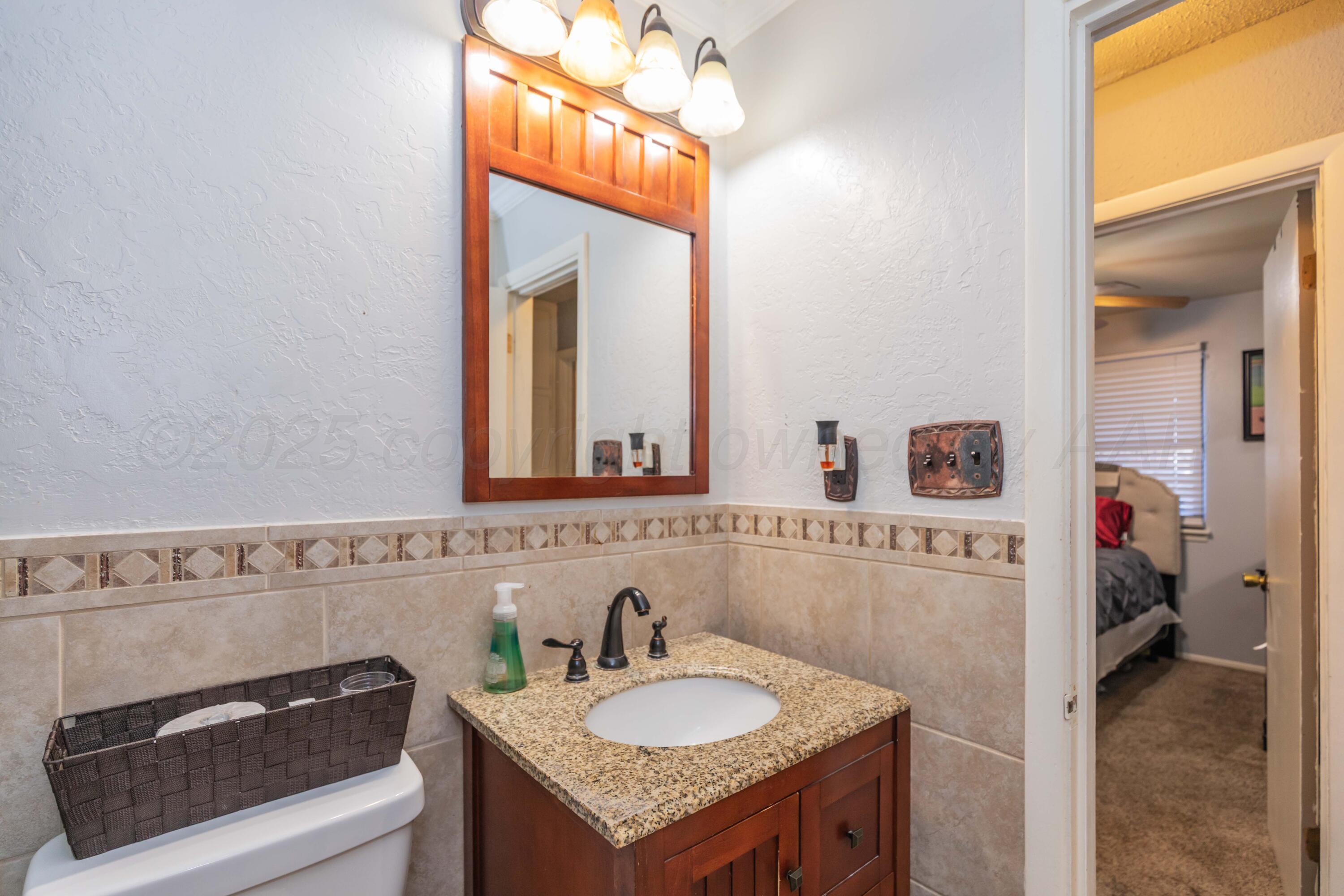 1208 Pecan Street Amarillo, TX 79107 - Photo 20 of 34 a bathroom with a granite countertop sink and a mirror