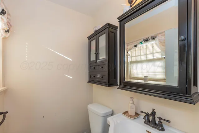 a bathroom with a toilet a sink and a window