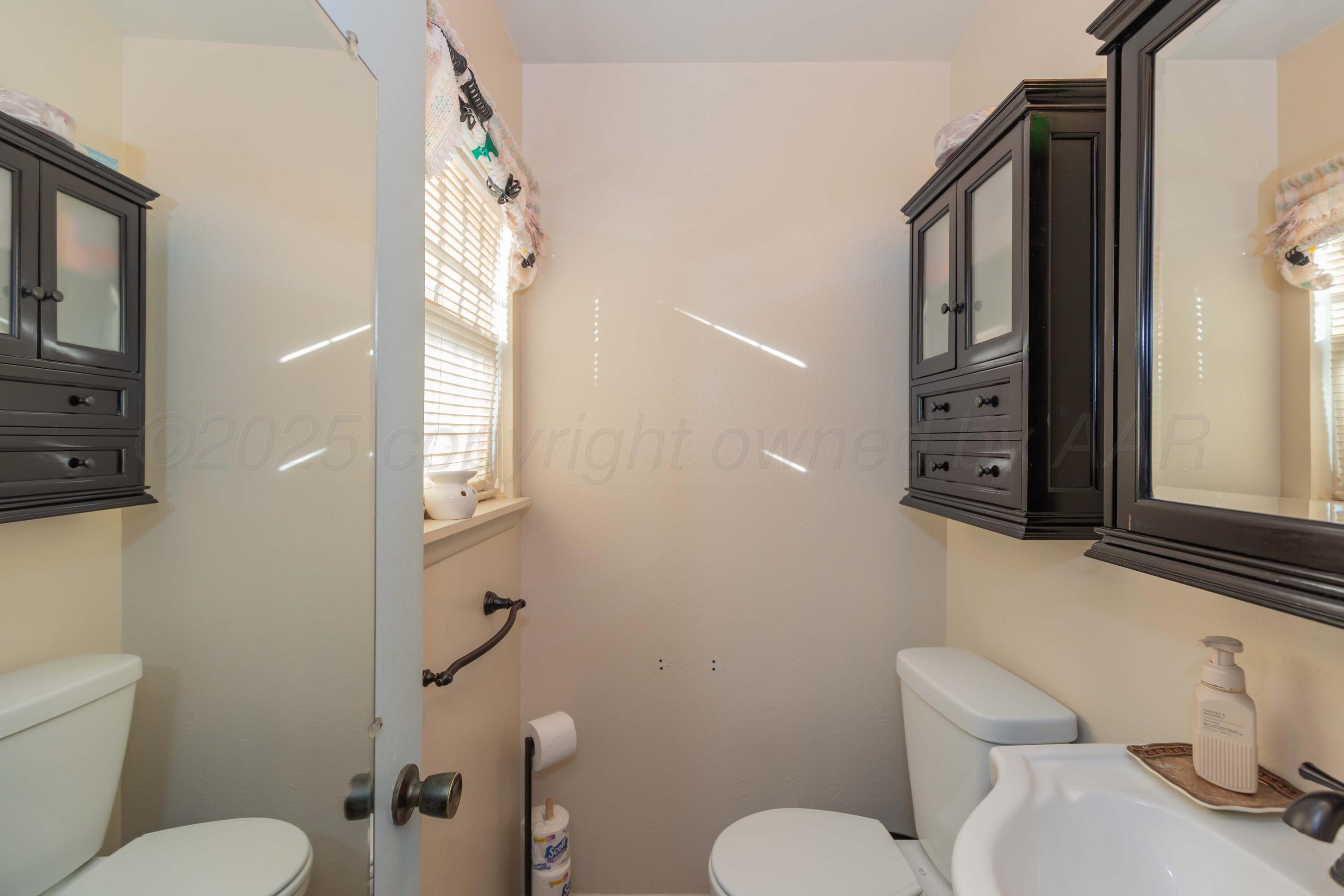 1208 Pecan Street Amarillo, TX 79107 - Photo 25 of 34 a white toilet sitting next to a bathroom sink