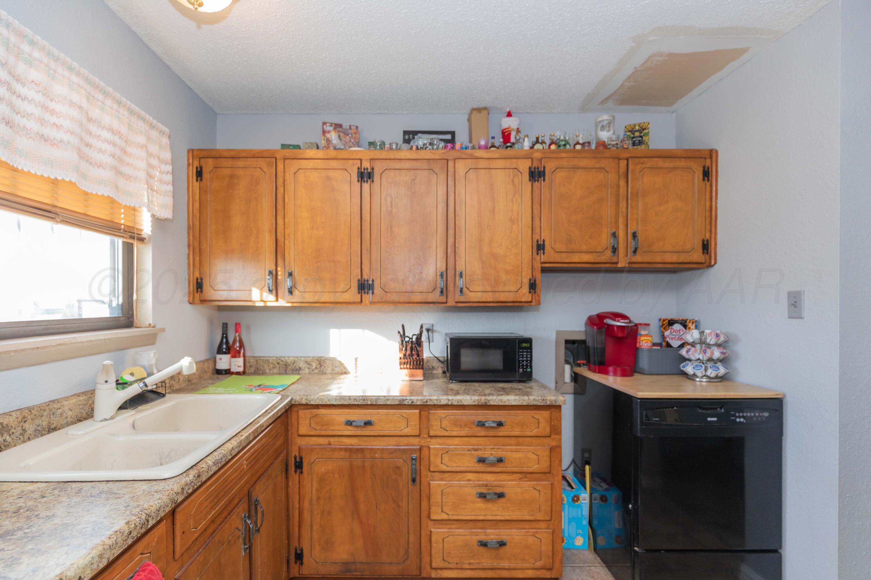 1208 Pecan Street Amarillo, TX 79107 - Photo 9 of 34 a kitchen with stainless steel appliances granite countertop a sink dishwasher and cabinets with wooden floor