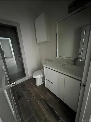 a bathroom with a granite countertop sink mirror vanity and toilet