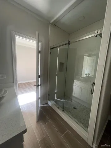 a bathroom with a glass door shower and a sink