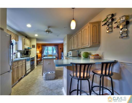 100 Winthrop Road Edison, NJ 08817 - Photo 8 of 18 a kitchen with a dining table chairs and refrigerator