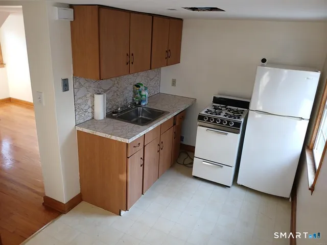 a kitchen with a stove a refrigerator and a sink