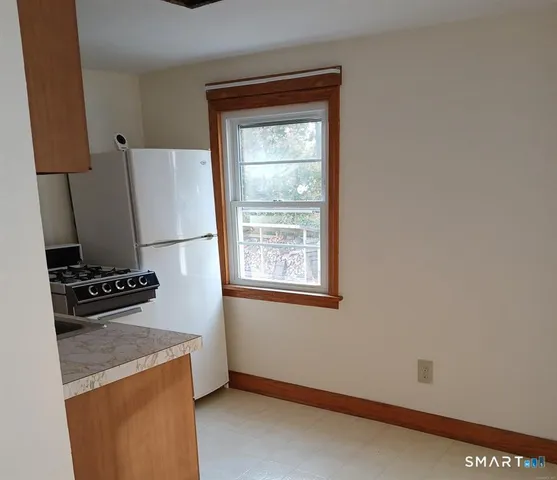 a kitchen with granite countertop a refrigerator and a stove