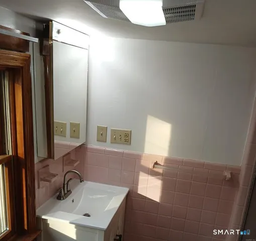 a bathroom with a sink a toilet and mirror