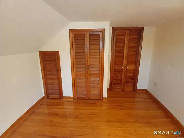 an empty room with wooden floor and closet