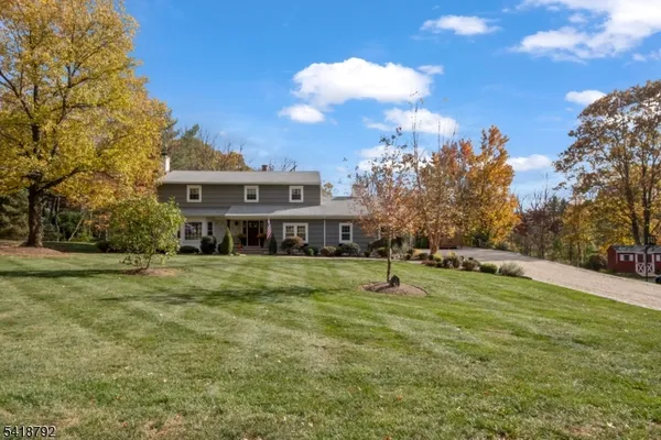 a view of a house with a big yard and large trees