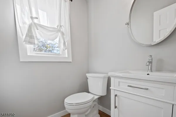 a bedroom with a bed next to a large window with dresser