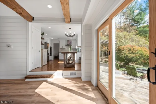 a patio with table and chairs and potted plants