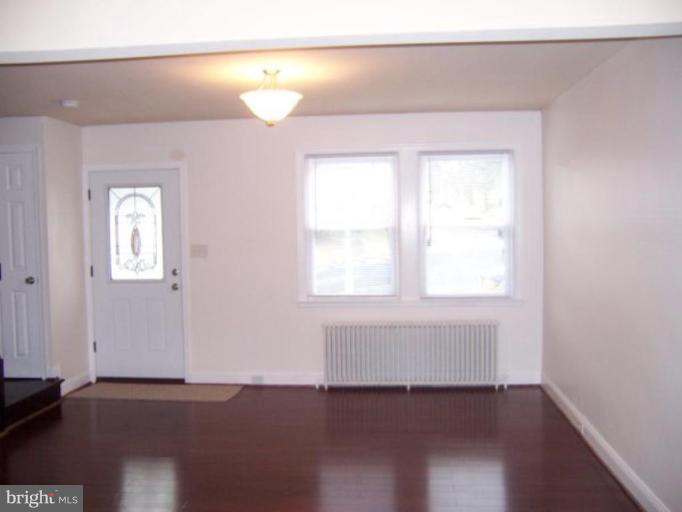 922 North Hill Road Baltimore, MD 21218 - Photo 3 of 14 an empty room with wooden floor and windows