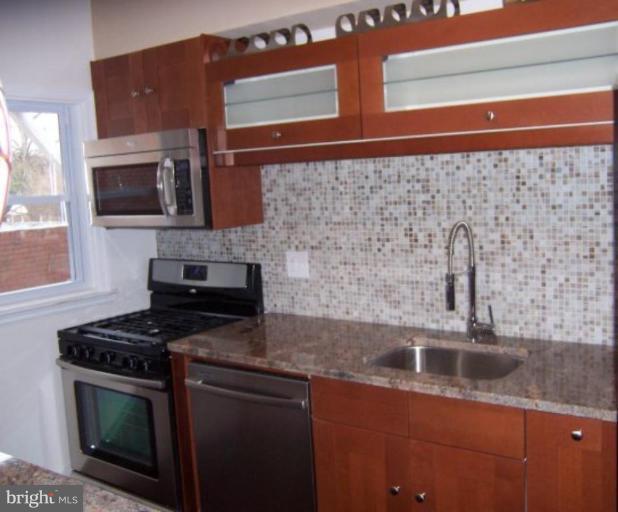 922 North Hill Road Baltimore, MD 21218 - Photo 5 of 14 a kitchen with stainless steel appliances granite countertop a sink stove and microwave