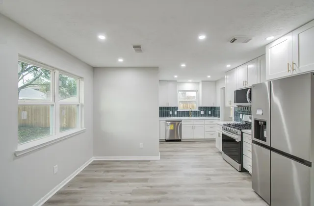 a kitchen with a refrigerator and a stove top oven