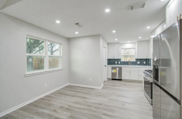 a kitchen with white cabinets and stainless steel appliances