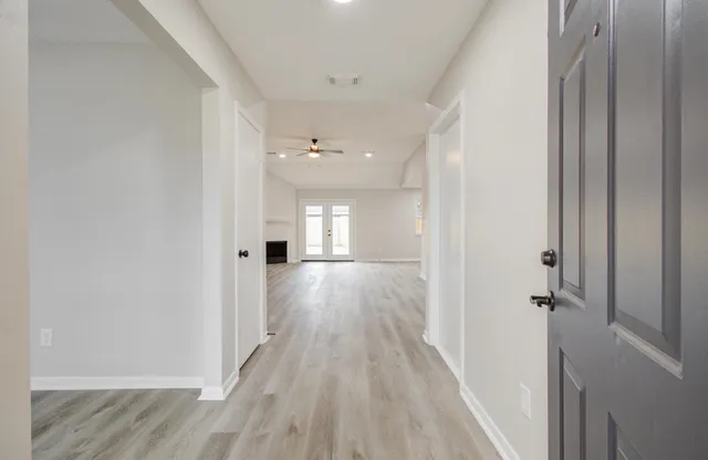 a view of a hallway with wooden floor