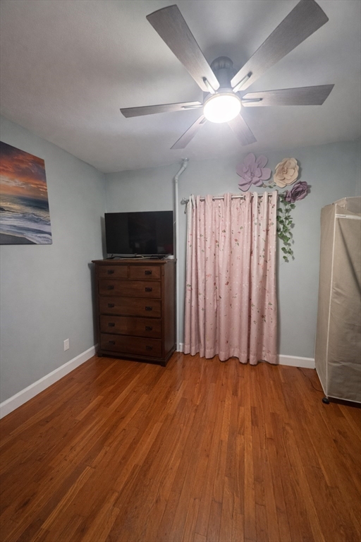 178 Cohasset Street, Unit 1 Worcester, MA 01604 - Photo 7 of 7 a view of an empty room with wooden floor and a ceiling fan