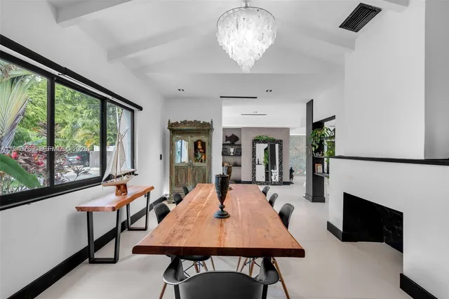 a dining room with furniture a chandelier and wooden floor