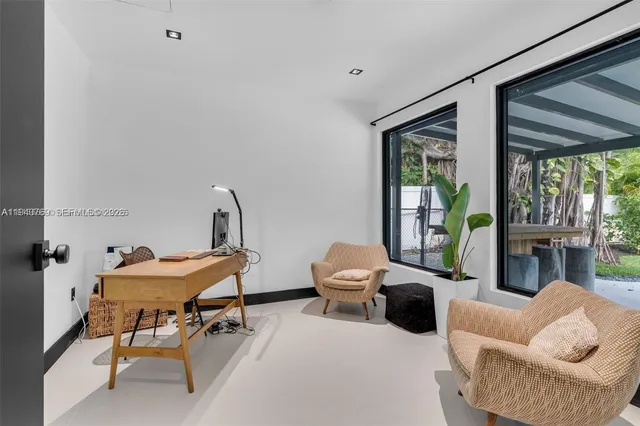 a bedroom with furniture and a large window