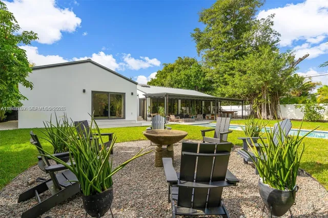 a view of a house with backyard sitting area and swimming pool