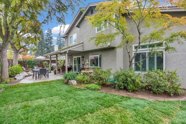a view of a chair and table in backyard of the house