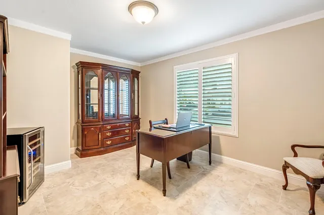a view of a workspace with furniture and a window