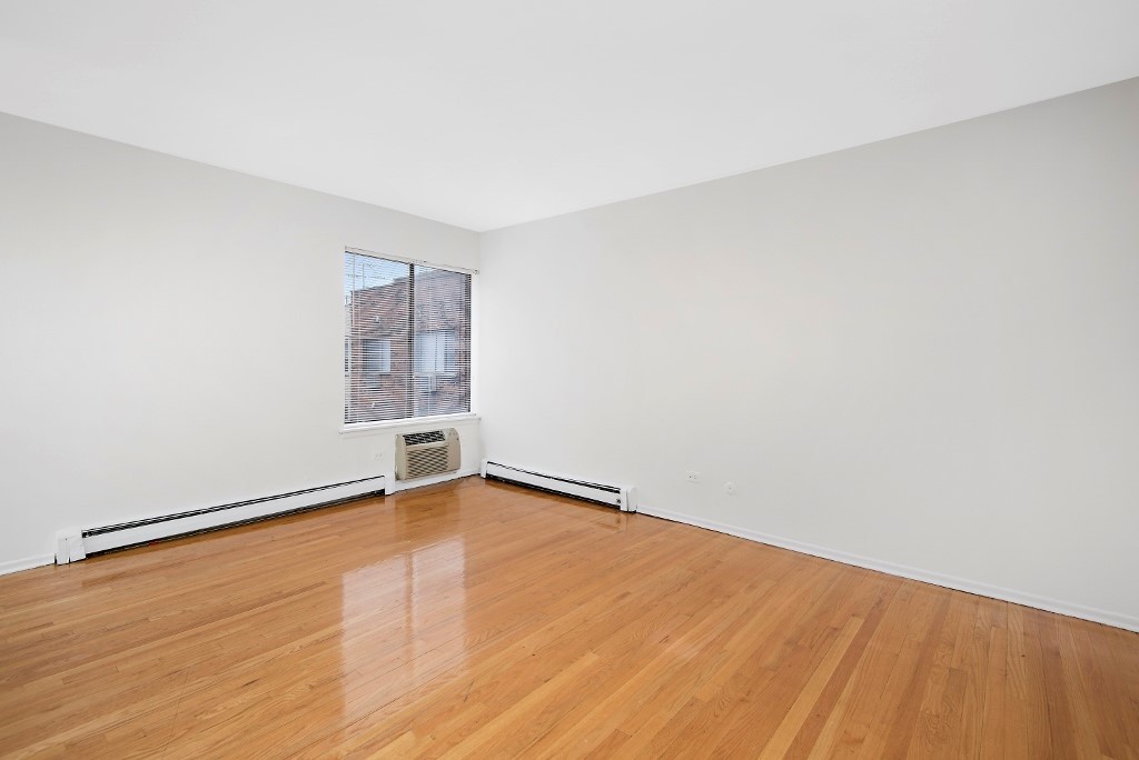 450 West Melrose Street, Unit 239 Chicago, IL 60657 - Photo 6 of 10 an empty room with wooden floor and windows