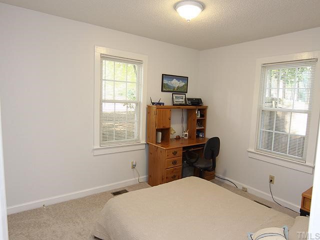 3600 Lynn Road Raleigh, NC 27613 - Photo 8 of 12 a bedroom with a bed and a window